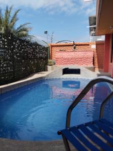 een blauwe stoel naast een zwembad bij Posada del sol in Manta