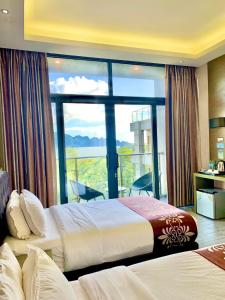 a hotel room with two beds and a large window at Vienna Hotel in Coron
