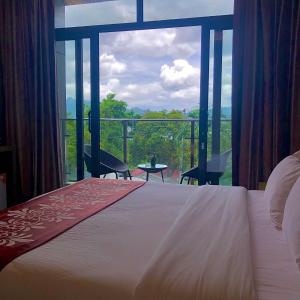 a bedroom with a bed and a large window at Vienna Hotel in Coron