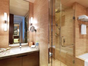y baño con lavabo y ducha. en The QUBE Hotel Yangzhou, en Yangzhou
