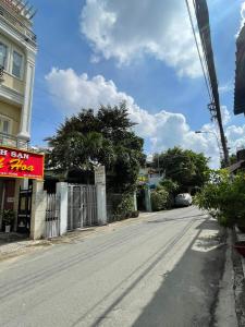 een lege straat met een bord aan de zijkant van een gebouw bij QUỲNH HOA HOTEL in Ho Chi Minh-stad
