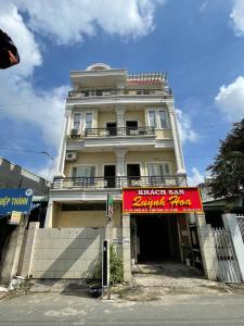 een wit gebouw met een rood bord ervoor bij QUỲNH HOA HOTEL in Ho Chi Minh-stad