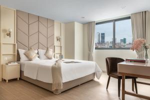 um quarto de hotel com uma cama, uma secretária e uma janela em TK Central Serviced Apartments em Phnom Penh