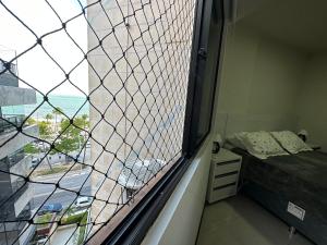 una finestra in una camera con un letto e una finestra di Apartamento á beira mar em Maceió a Maceió