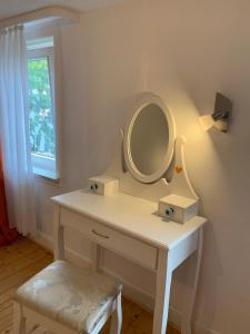 a white dressing table with a mirror and a stool at Gemütlichkeit im Fachwerkhaus, 3 Schlafzimmer, Balkon, Parkplatz in Wolfhagen
