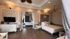 Cette chambre d'hôtel dispose d'un lit, d'une télévision et d'une chambre. dans l'établissement Vườn Vua Resort & Sun Villas Khu Thanh Liên, à Ðồng Phú