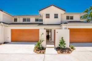 a house with a wooden garage door at Ocean Walk - villa with pool near Main Beach in Byron Bay