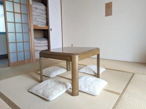 Amanohashidate Youth Hostel - Vacation STAY 94805v في ميازو: طاولة في غرفة مع المناشف على الأرض