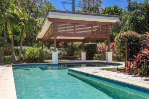 a swimming pool with a pergola next to a house at A Perfect Stay - Drift in Byron Bay