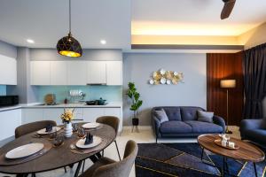 吉隆坡的住宿－Sentral Suites Kl Sentral By Luxe Home，客厅配有两张桌子和一张沙发