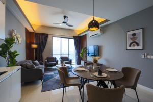 a living room with a table and chairs at Sentral Suites Kl Sentral By Luxe Home in Kuala Lumpur
