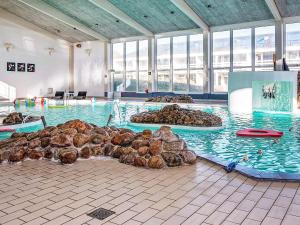 una piscina con un mucchio di rocce in acqua di Holiday home Ringkøbing III a Ringkøbing