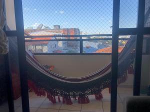 a hammock in a window with a view of a city at Quarto privativo in Campina Grande