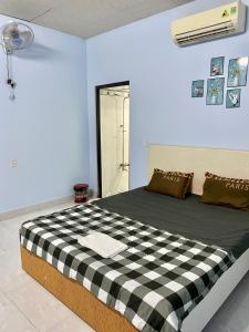 a bedroom with a black and white checkered bed at Nhà nghỉ Đoàn Gia in Dồng Xoài