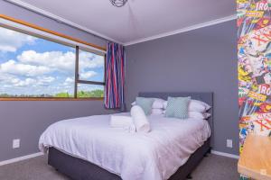 a bedroom with a large bed with a window at Spacious with fabulous views overlooking the city in Hamilton