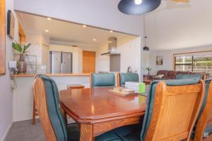 a kitchen and dining room with a wooden table and chairs at Spacious with fabulous views overlooking the city in Hamilton
