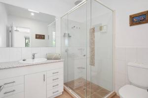 a white bathroom with a shower and a sink at Golden Sands Rye in Rye +12 photos