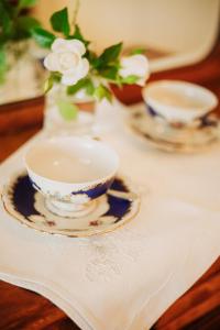 a table with two tea cups and a vase with flowers at La Aguada Hotel Boutique in San Rafael