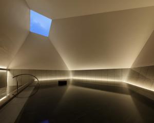 a swimming pool in a bathroom with a blue window at OMO7 Osaka by Hoshino Resorts in Osaka