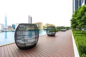 two benches sitting on a deck near the water at Sentral Suites Kl Sentral By Luxe Home in Kuala Lumpur