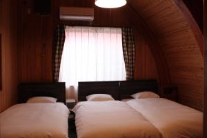 two beds in a room with a window at Nagashima cottage - Vacation STAY 9014 in Kuwana