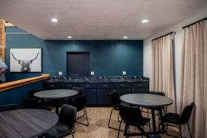 two tables and chairs in a room with blue walls at OK Welcome Home Hotel in Alva