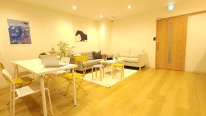 a living room with a table and chairs and a couch at Acro Capsule Hotel Namba Dotonbori in Osaka