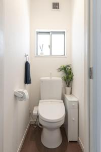 a white bathroom with a toilet and a window at The Beach Front Miurakaigan - Vacation STAY 10780 in Miura