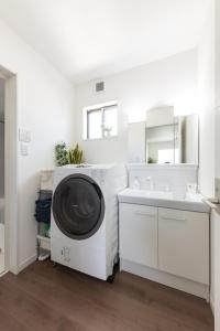 a white laundry room with a washing machine and a sink at The Beach Front Miurakaigan - Vacation STAY 10780 in Miura