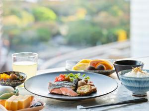 une table avec des plaques alimentaires et un verre de jus d'orange dans l'établissement Mitsui Garden Hotel Ginza Premier, à Tokyo