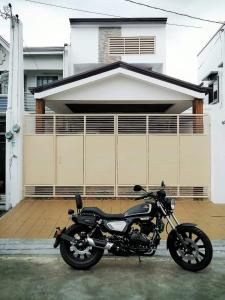 a motorcycle parked in front of a house at Ruiz Domicile in Kawit