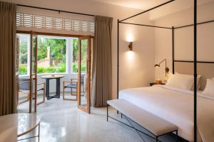 a bedroom with a bed and a dining room with a table at The Charleston in Galle