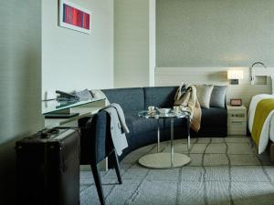 una camera d'albergo con divano e letto di Mitsui Garden Hotel Ginza Premier a Tokyo