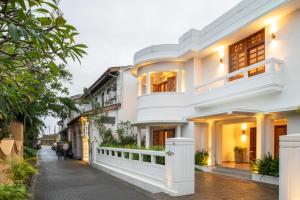 a white house with people walking down a street at The Charleston in Galle