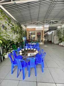 comedor con sillas azules y mesa en Nhà Nghỉ Tiến Phúc 1, en Long Hai