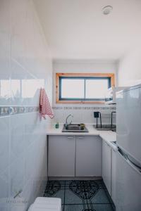 eine kleine weiße Küche mit einem Waschbecken und einem Fenster in der Unterkunft Hotel Fundo Las Tortolas in Limache