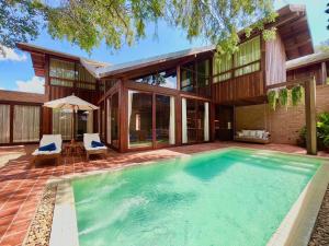 a swimming pool in front of a house at Athita The Hidden Court Chiang Saen Boutique Hotel SHA Plus CERTIFIED in Chiang Rai