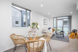 a living room with a glass table and chairs at 3 BDR CBD Get Away in Auckland