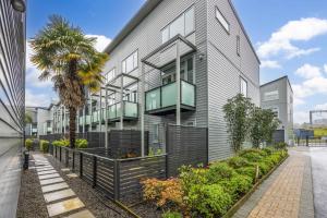 an apartment building with a balcony and a palm tree at 3 BDR CBD Get Away in Auckland