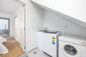 a laundry room with a washing machine and a staircase at 3 BDR CBD Get Away in Auckland