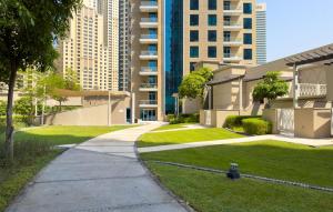 a sidewalk in front of a building with grass and buildings at Boutique Apartment Sea Views - Dubai Marina in Dubai