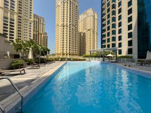 a large swimming pool in a city with tall buildings at Boutique Apartment Sea Views - Dubai Marina in Dubai