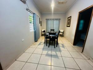 a dining room with a table and chairs on a tiled floor at Casa en Puero Cortes in Puerto Cortés