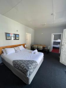 a bedroom with a large bed and a table at Mountain View Motel in Queenstown