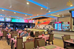 a dining room with people sitting at tables in a restaurant at The Grand Lodge Pattaya in Pattaya Central