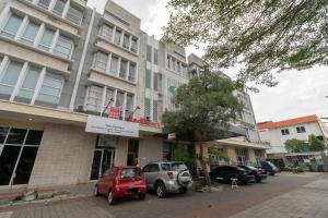 una calle con coches estacionados frente a un edificio en RedDoorz near Universitas Esa Unggul Bekasi Harapan Indah en Bekasi