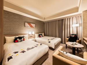 a hotel room with two beds with hello kitty pillows at Mitsui Garden Hotel Kumamoto in Kumamoto