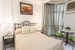 una camera d'albergo con un letto, un tavolo e delle sedie di Hotel Canelsa a Tacloban