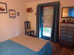 1 dormitorio con 1 cama, vestidor y ventana en Casa de campo, surf, pesca y golf en Miramar
