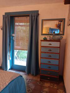 um quarto com uma cómoda e uma janela com cortinas azuis em Casa de campo, surf, pesca y golf em Miramar